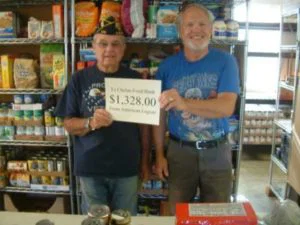 Brian Strausbaugh present cash donations totaling $1328 to Lake Chelan Food Bank director Richard Springer