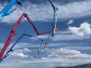 View of sky and extended pump trucks displaying American flags, as seen from below