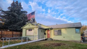 Front view of single-story home with access ramp and American flag, the current home of the Chelan County VSO.